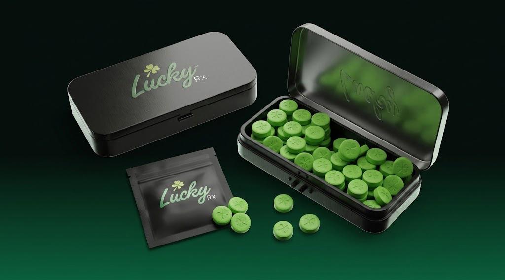 Lucky WOW metal case filled with green clover tablets, next to a closed case and a travel pouch